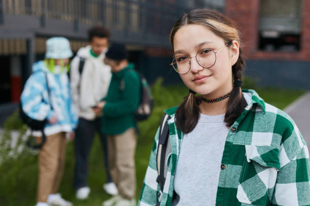 istock Young schoolgirl standing in school yard 1405791739