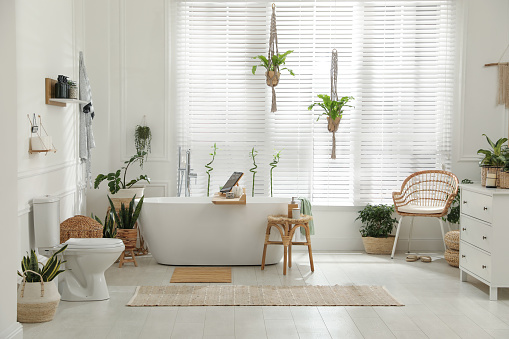 istock Stylish white tub and green houseplants in bathroom. Interior design 1405791841