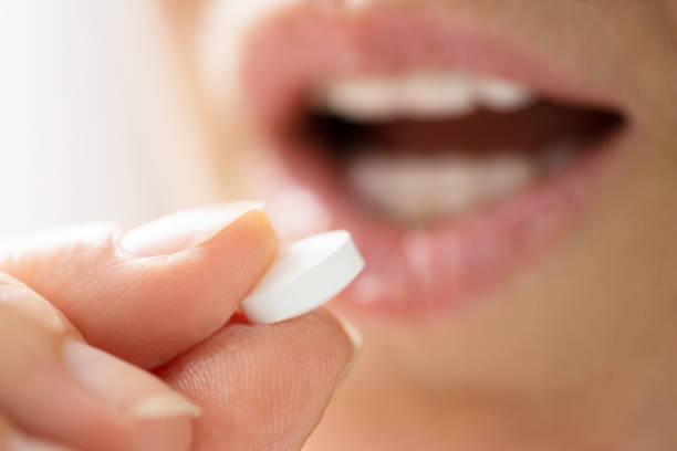 istock Close-up Of Female Taking White Pill 1405791861