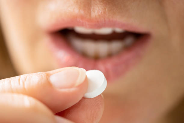 istock Close-up Of Female Taking White Pill 1405791872