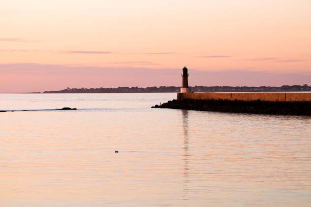 Beautiful colored sunset on Le Croisic jetty with lighhouse \
