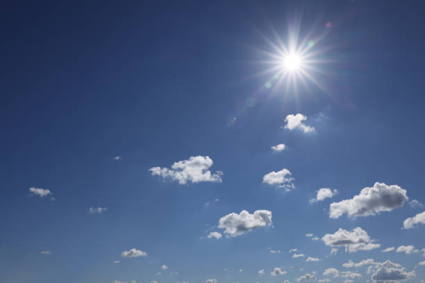 Beautiful white fluffy clouds and sun in blue sky