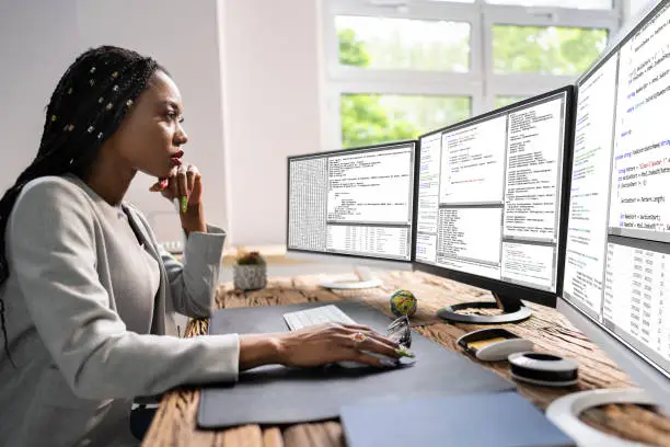 Photo of African American Coder Using Computer At Desk