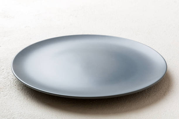 istock Perspective view of empty grey plate on cement background. Empty space for your design 1405793529