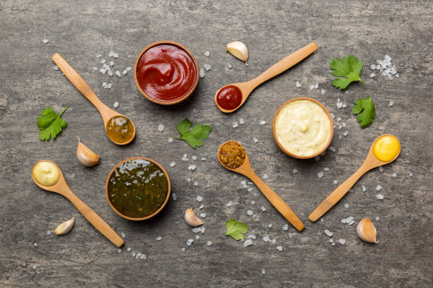 different sauces in spoons on table background, flat lay top view - tomato curry imagens e fotografias de stock