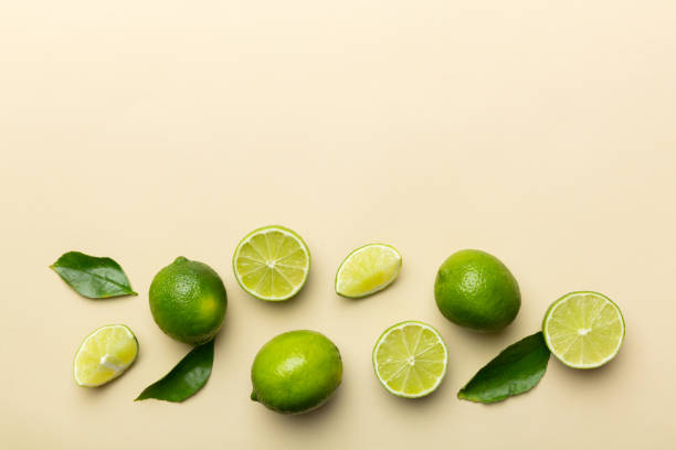 istock Lime fruits with green leaf and cut in half slice isolated on white background. Top view. Flat lay with copy space 1405793618