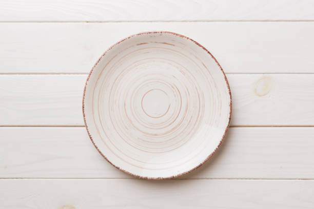 istock Top view of empty colorful plate on wooden background. Empty space for your design 1405793625