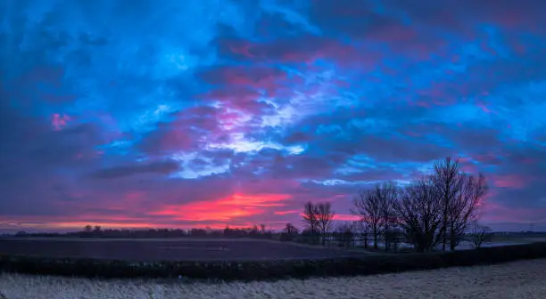 Spectacular Winter sunrise over flat agricultural land in the Fens in the East of England, Spalding, Lincolnshire.