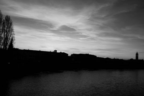 Silhouette at sunset - the Italian medieval city of Verona on the river Adige in black and white