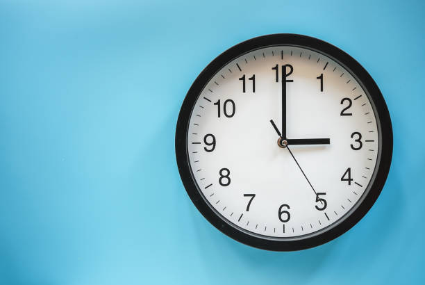 istock Classic black and white analog clock on blue background at Three o'clock with copy space 1405796491