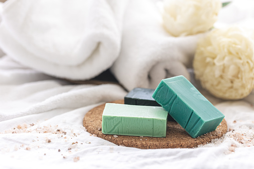 Spa composition with colorful handmade soap close-up on a blurred background with towels.