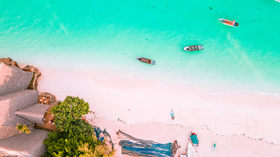 Nungwi Beach, Zanzibar - Tanzania - June 18 2022 - Boats on the indian ocean on a sunny cloudy day during sunrise.