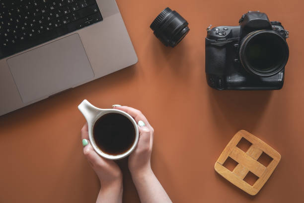 istock Photographer's workplace with camera and lens, flat lay. 1405802126