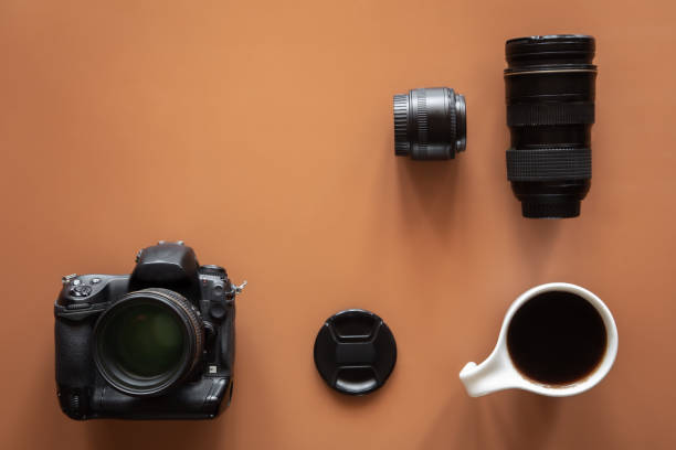 istock Photographer's workplace with camera and lens, flat lay. 1405802133