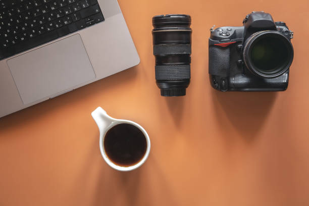 istock Photographer's workplace with camera and lens, flat lay. 1405802147