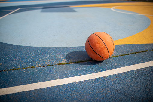 Basketball ball on the multicolored basketball court