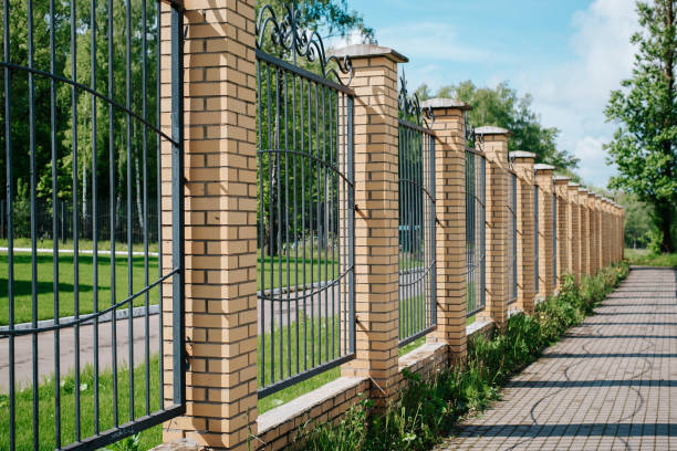istock Fence with wrought iron lattice and brick pillars outdoors on sunny summer day, side view 1405807325