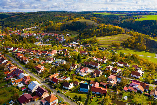 Family homes in the country side in winter time, by the forest. Aerial view, drone point of view, flying over a new housing development. Situated in the country side in Slovenia. Forming a small new neighborhood. Modern architecture had a an influence on design of these new family homes.