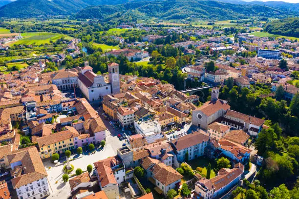 Aerial view of Cividale del Friuli cityscape on banks of Natisone river overlooking Catholic cathedral and ancient bridge Ponte del Diavolo, Italy