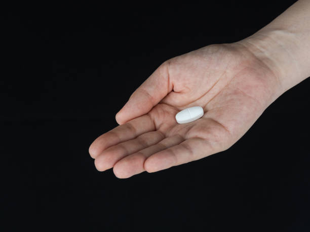 istock Pills in Hand Close-up on Black Background 1405813681