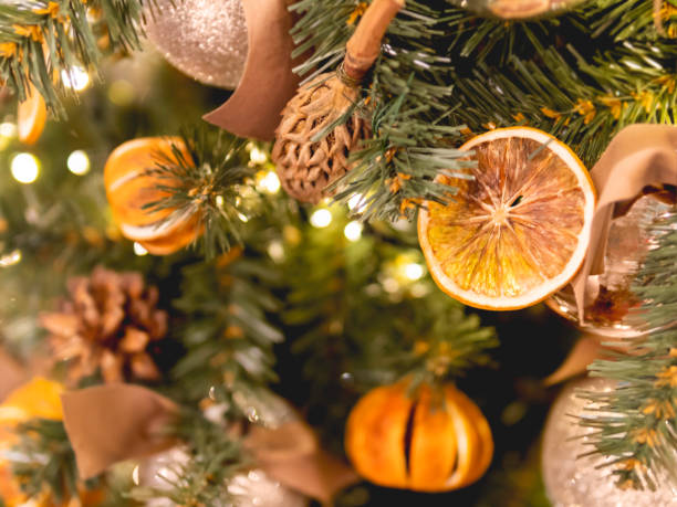 istock Christmas tree with dried lemons and natural decorations. Fir tree decorated with light bulbs and shiny balls for New Year celebration. 1405816166