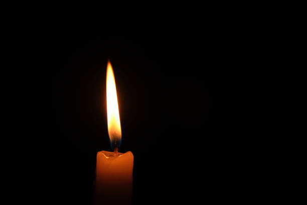 istock Flame burning candle black background.Concept memory and sorrow. 1405820496