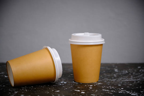 istock Two disposable paper cups to take away against gray wall. 1405820549