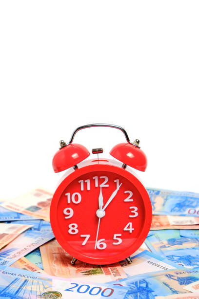 istock Russian rubles and red alarm clock white background.Time Russian ruble. 1405820621