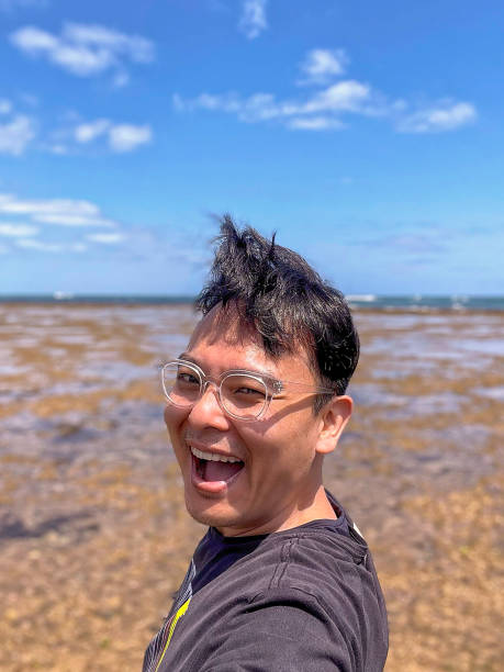 istock Handsome Japanese man on a beach. 1405821975