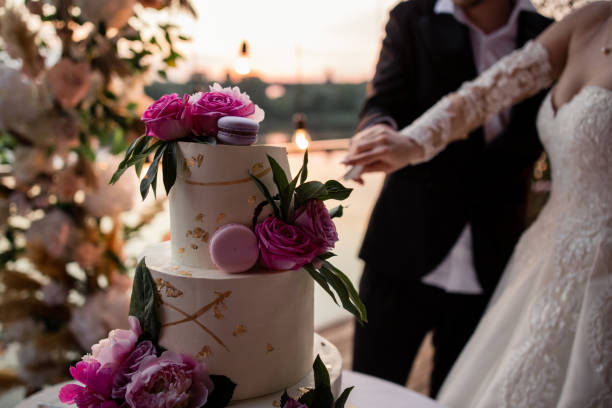 una novia y un novio en la boda cortando el pastel de bodas - wedding cake newlywed wedding cake fotografías e imágenes de stock