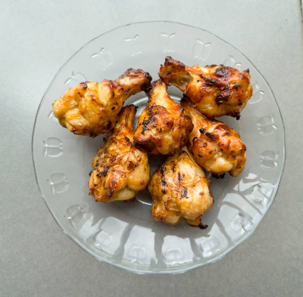 istock Tasty grilled chicken wings on dish, top view, selective focus 1405823937