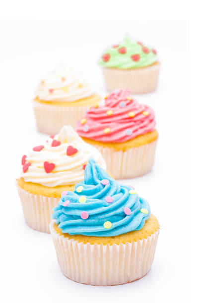 Colorful cupcakes with sugar decoration against white background