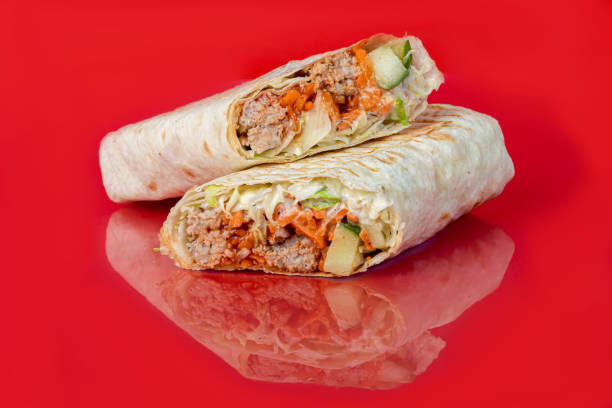 istock Chicken roll with vegetables. Fresh cabbage, cucumbers, carrots and greens. On a colored background. Shawarma. 1405826639