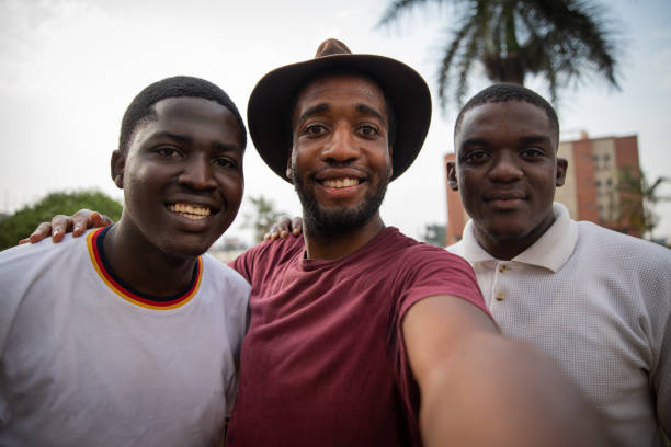 tres jóvenes amigos se toman una selfie y sonríen y están felices, chicos africanos. - cousin fotografías e imágenes de stock