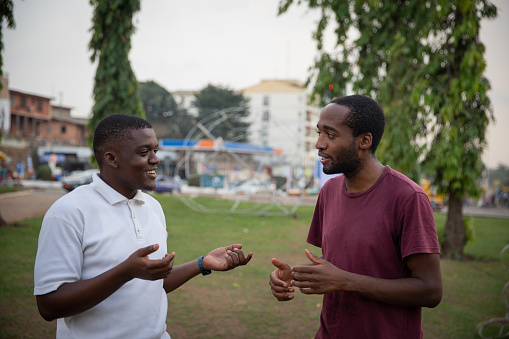 Two friends meet to talk, African boys in the open air in a public park