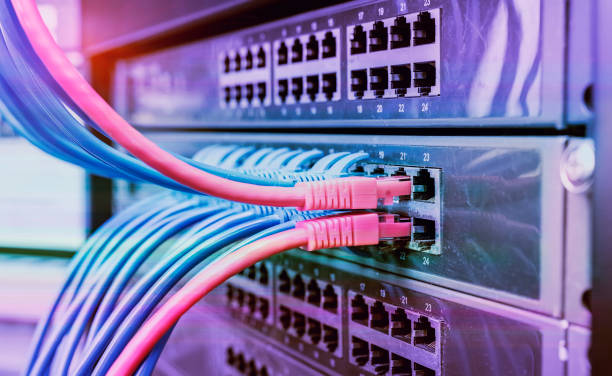 server rack with blue and red internet patch cord cables connected to black patch panel in data server room - network server rack data center in a row imagens e fotografias de stock