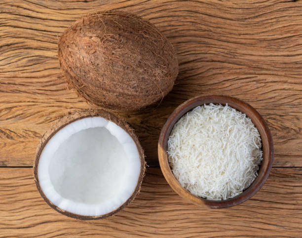 istock Grated coconut flakes in a bowl with fruit over wooden table 1405832785