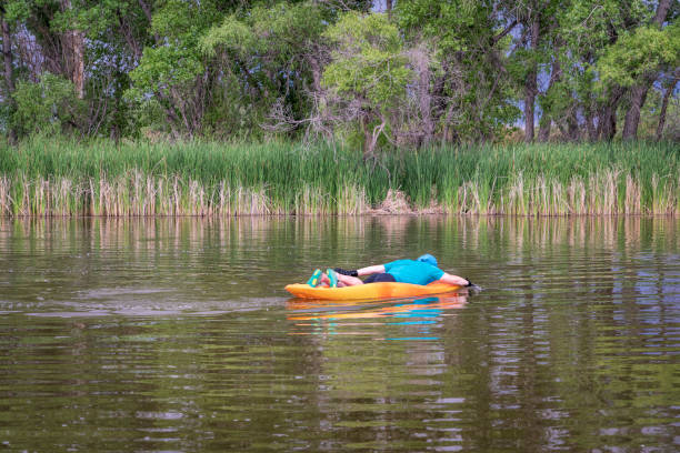 istock athletic, senior man is paddling a prone kayak 1405834543