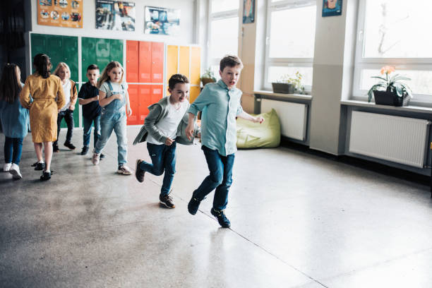 group of elementary school children running in the corridor