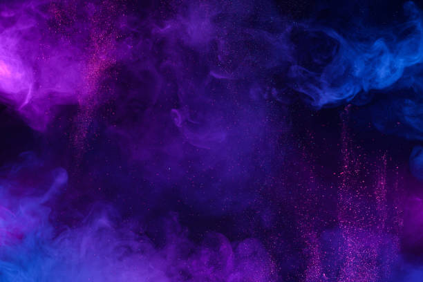 nuvole colorate blu e rosa di fumo e particelle di polvere glitterata lucida esplodono sullo sfondo - viola foto e immagini stock