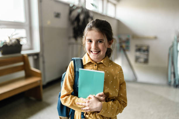 istock portraits of happy elementary schoolgirl holding workbook 1405835511