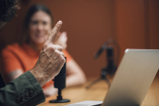 animateur de radio pointant du doigt lors d’une interview - interview meeting business women photos et images de collection