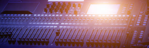 istock Audio mixing console with faders and adjusting knobs, Sound mixer with motorized faders, Professional audio studio sound mixer console board panel with recording, TV equipment. Blue tone and close-up image with flare light effect. 1405838281