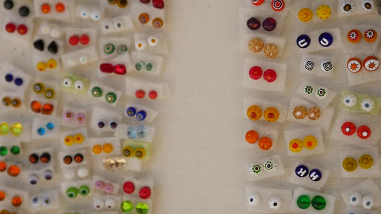 Decorative ornaments for sale on showcase. Earrings, bracelets, pendants and various souvenirs for tourists. Big choice. Shop of hand made jewelry merchant. Rovinj, Istria, Croatia - 2022, circa June