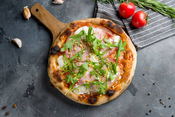 istock Pizza with Parma ham and arugula top view on grey table 1405839434