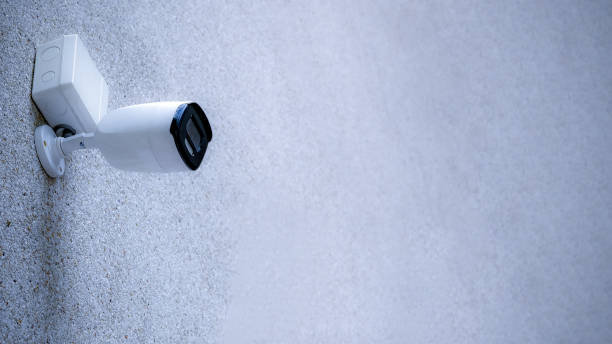 istock CCTV camera on a wall. A blurred night cityscape background. lungs separated, IP CCTV camera install by have water proof cover. 1405839451