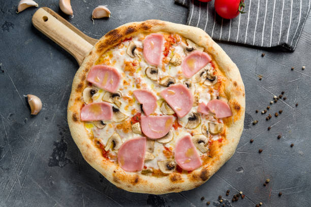 istock Pizza with ham and mushrooms on grey table top view 1405839913