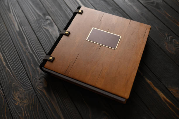 An old photo album with a wooden cover and a shield on a rustic table. free logo stock photo
