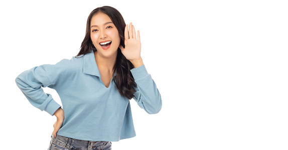 Happy young asian woman try to hearing you overhear listening sound to gossip looking at camera isolated on white background and copy space Studio shot hearing gesture get good news with smile face