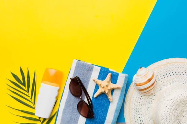 istock Beach accessories straw hat and seashell on colored table. Summer concept background 1405841836